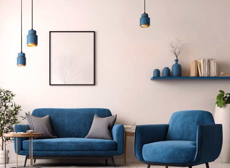 Moderno uređen dnevni boravak sa plavom stolicom i sofom, dekorativnim policama i visećim lampama u ujednačenoj boji.