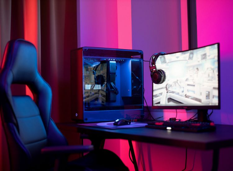 Kompjuterska stolica pored gejming računara u modernom osvetljenom prostoru
