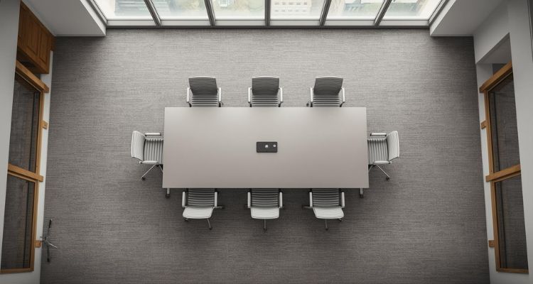 Moderan konferencijski sto u kancelariji snimljen iz ptičje perspektive, sa dovoljno prostora za stolice i prolaz.