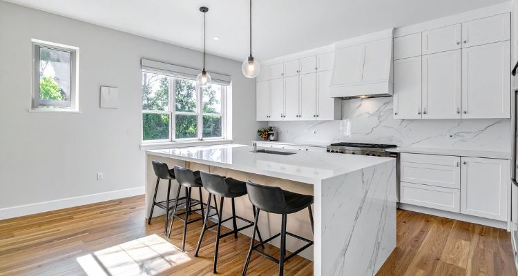 Šank stolice postavljene uz kuhinjsko ostrvo sa visokim radnim pultom u savremenom kuhinjskom prostoru