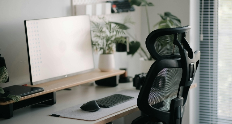 Ergonomska radna stolica sa mrežastim naslonom u modernom kućnom radnom prostoru.